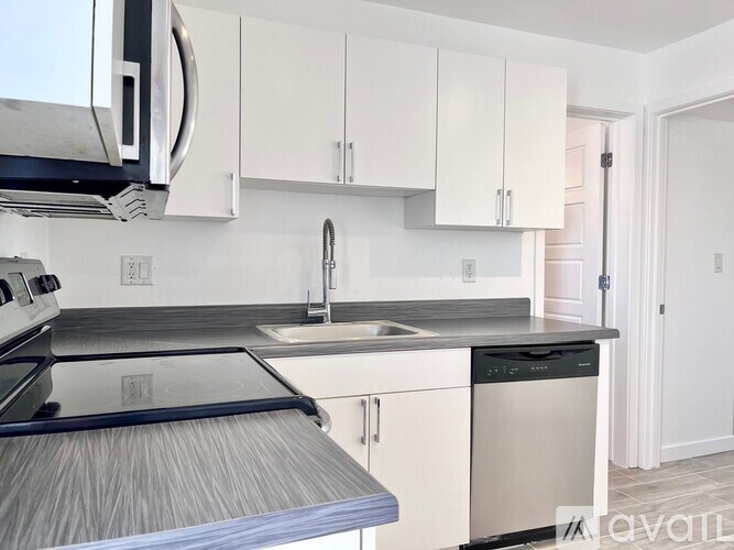 A kitchen with white cabinets and a stainless steel dishwasher.