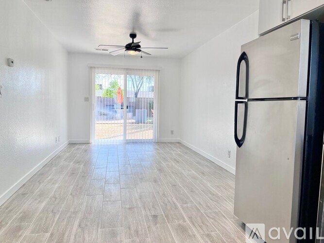A spacious room with a ceiling fan and a door leading to a balcony.