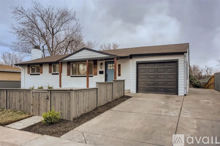 A house with a grey garage door and a brown fence.