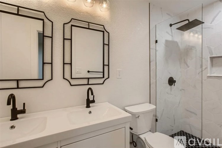 A white bathroom with a toilet, sink, and mirror.