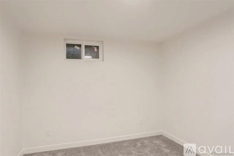 A room with a window and a carpeted floor.