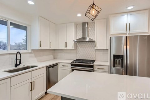 A kitchen with white cabinets and a large island.