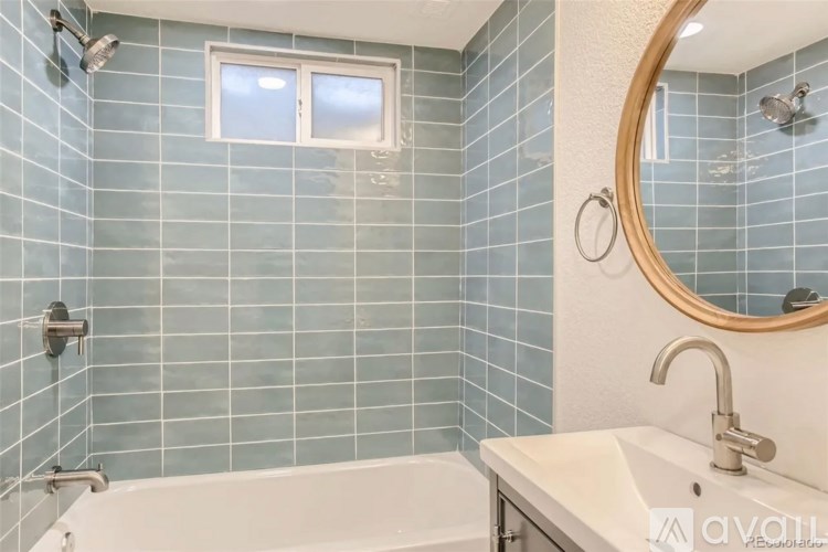A bathroom with a white tub, sink, and mirror.