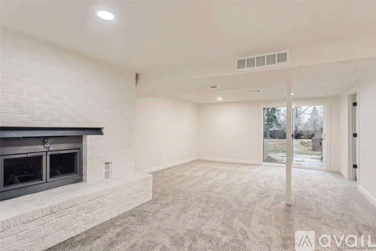 A spacious living room with a fireplace and a carpeted floor.