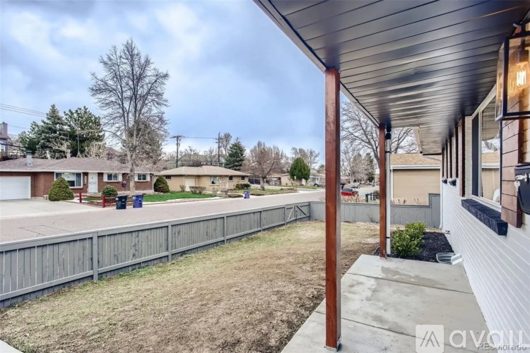 A view of a residential area with houses and a fence.
