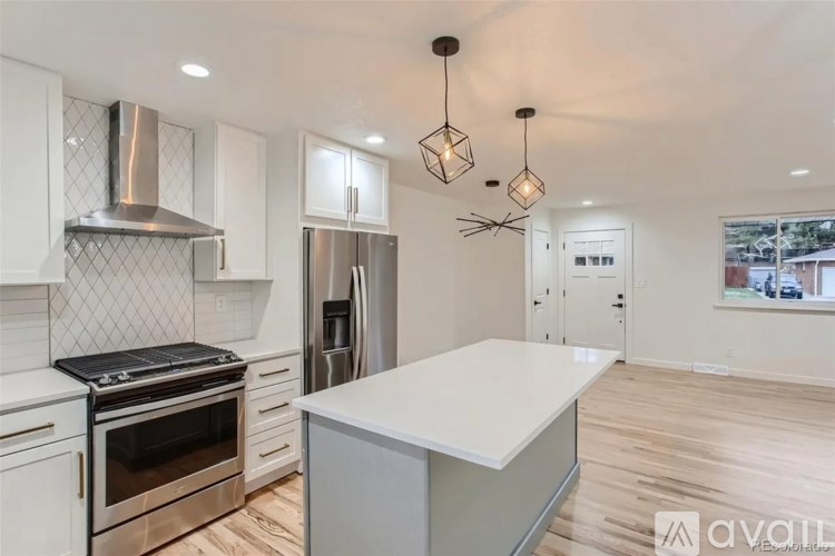 A kitchen with white cabinets and a stainless steel refrigerator.