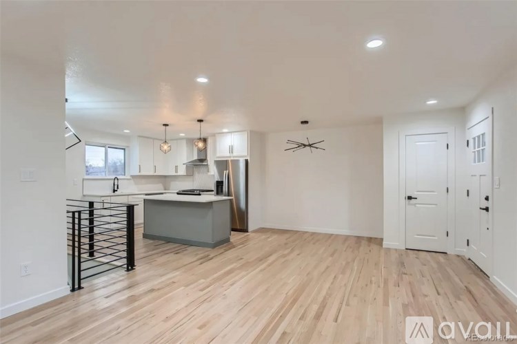 A kitchen with a wooden floor and white walls.