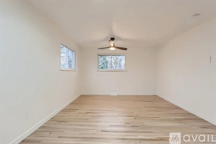 A room with wooden flooring and a ceiling fan.