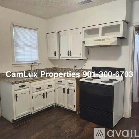 A kitchen with white cabinets and a black stove top oven.