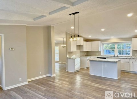 A spacious kitchen with white cabinets and a central island.