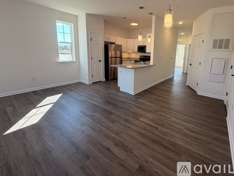 A spacious kitchen with a refrigerator, sink, and cabinets is available for rent.