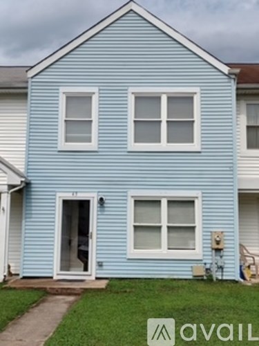 A blue house with a white door and windows.
