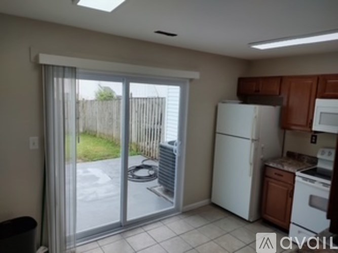 A kitchen with white appliances and brown cabinets.