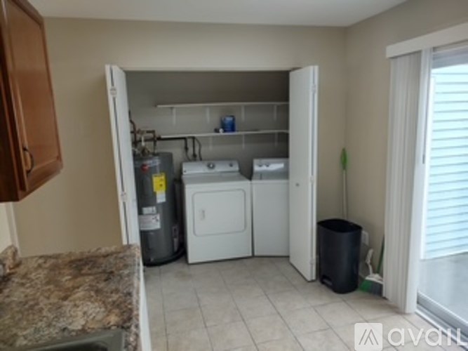 A kitchen with a washer and dryer in the laundry area.