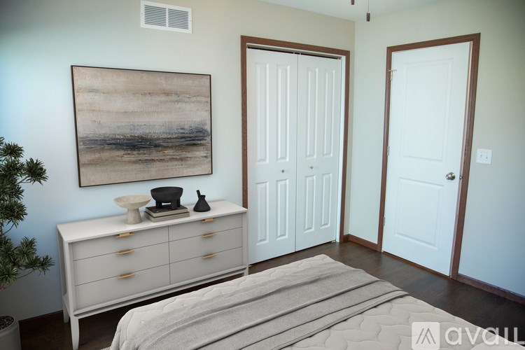 A room with a white dresser and a painting on the wall.