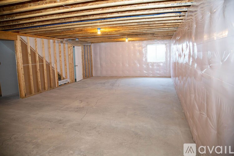 A room under construction with wooden framing and insulation on the walls.