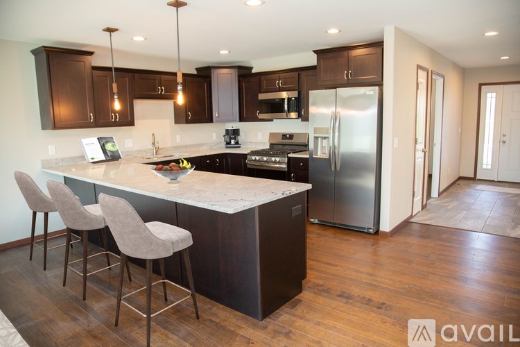 A kitchen with a bar and chairs.