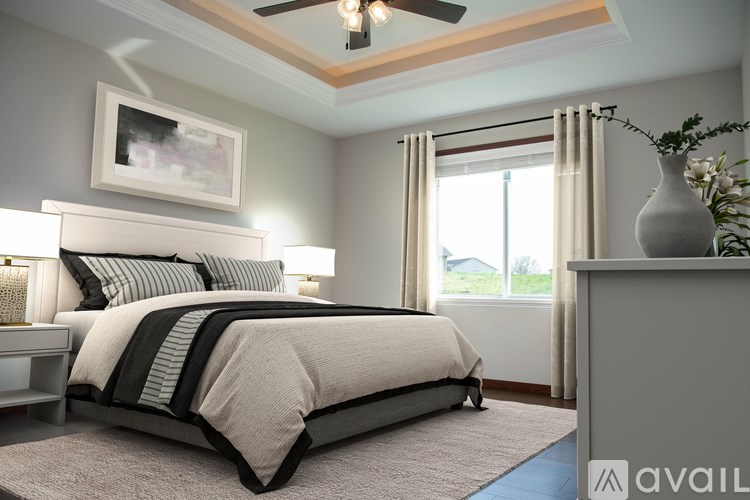 A bedroom with a large bed and a ceiling fan.