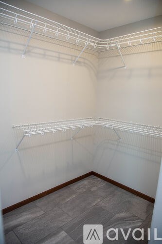 A room with a white wall and a grey floor.