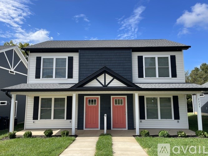 A two-story house with a red front door and white trim.