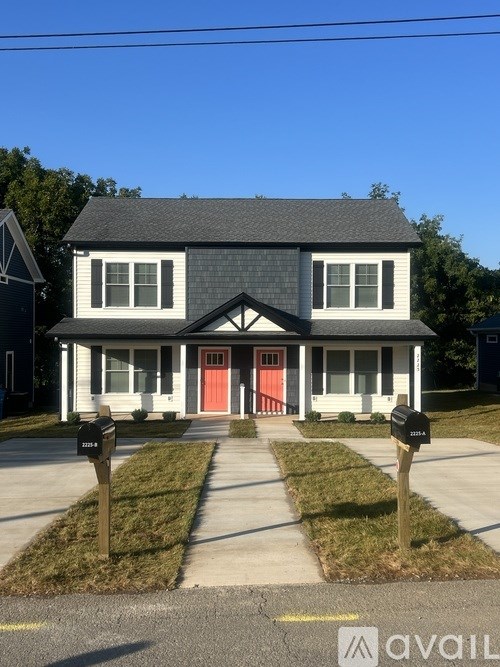 A two-story house with a red door and white trim.