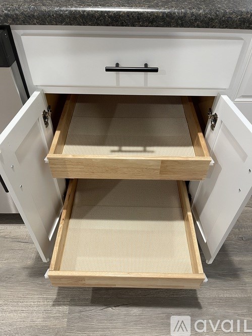 A kitchen drawer with a pull-out tray is open.
