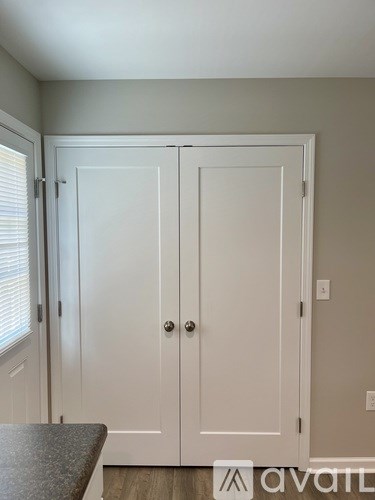 A white double door with a handle and a lock.