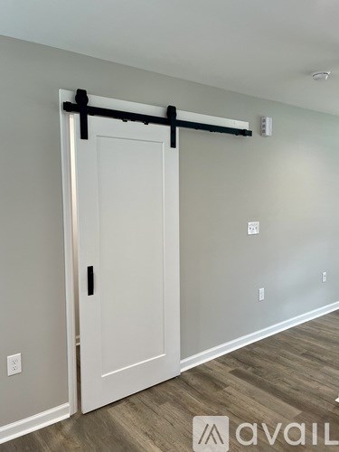 A white door with a black handle and a black bar above it.
