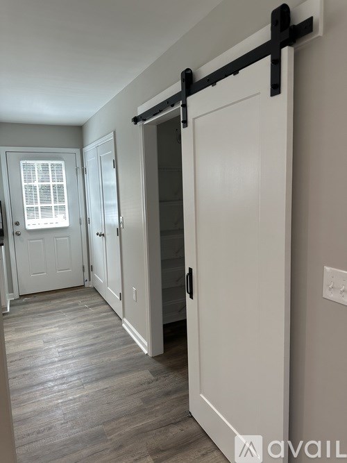 A hallway with a sliding door and a window.