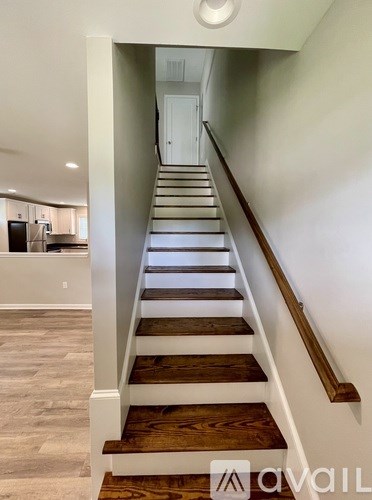 A staircase with wooden steps and a white railing.
