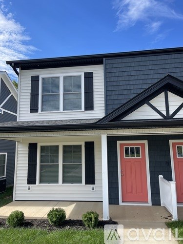 A house with a red door and a white fence.