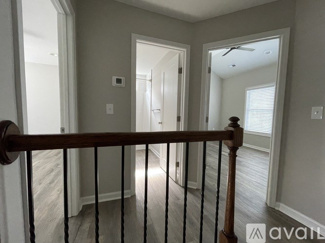 A balcony with a railing and a view of a hallway.