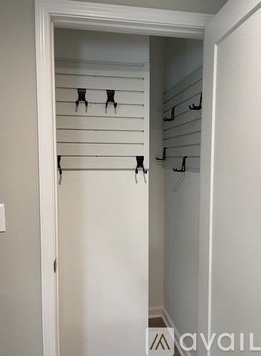 A white closet with black hangers.