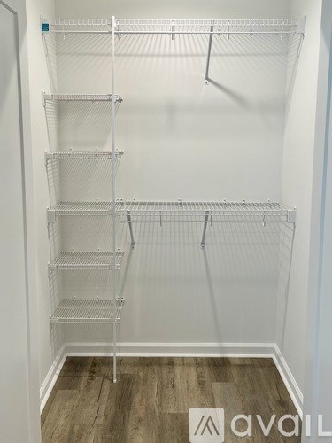 Empty shelves in a white room with wooden flooring.
