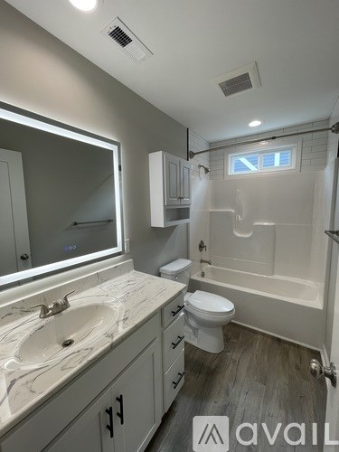 A bathroom with a marble countertop and a walk-in shower.