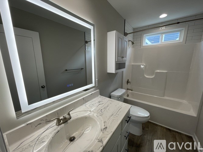 A bathroom with a sink, toilet, and bathtub.