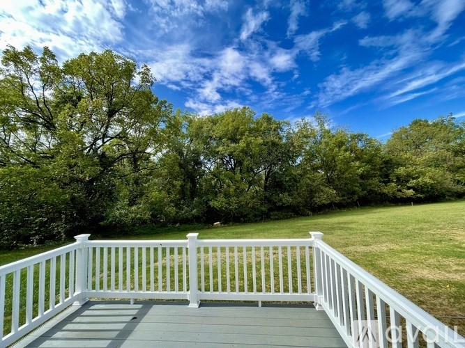 A white railing overlooks a green deck.