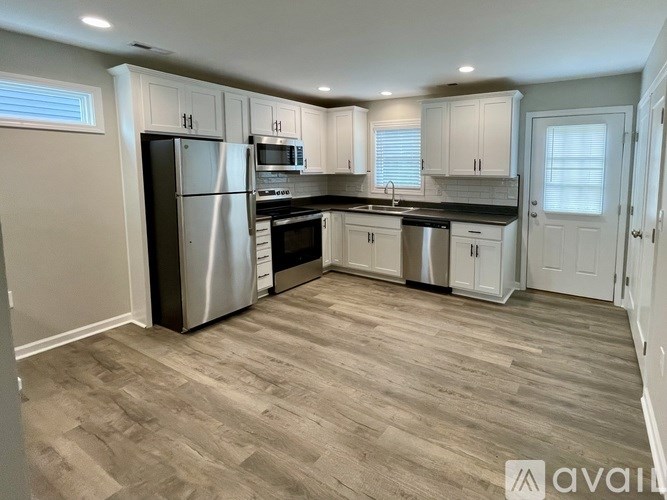 A kitchen with a refrigerator, oven, and microwave.