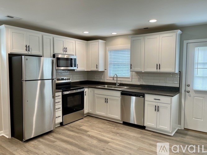 A kitchen with white cabinets and stainless steel appliances.