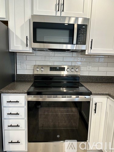 A modern kitchen with a stainless steel oven and microwave.