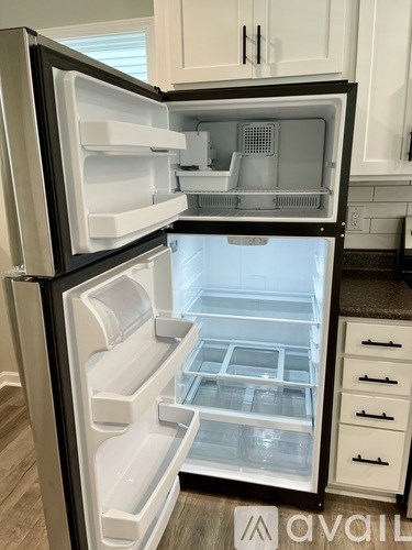 A black and white refrigerator with its door open is in a kitchen.