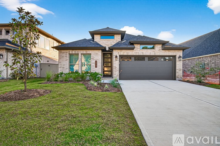 A house with a garage and a tree in front.