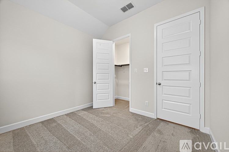 A room with two white doors and a carpeted floor.
