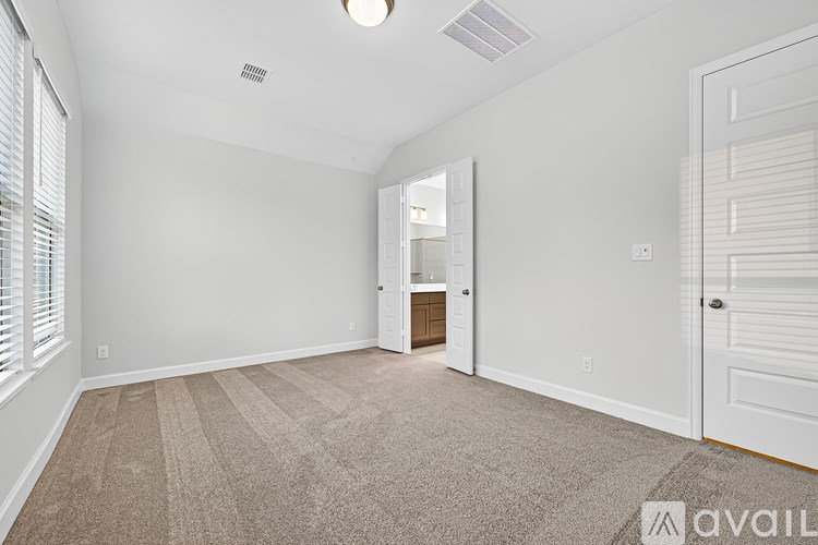A room with a carpeted floor and a door leading to another room.