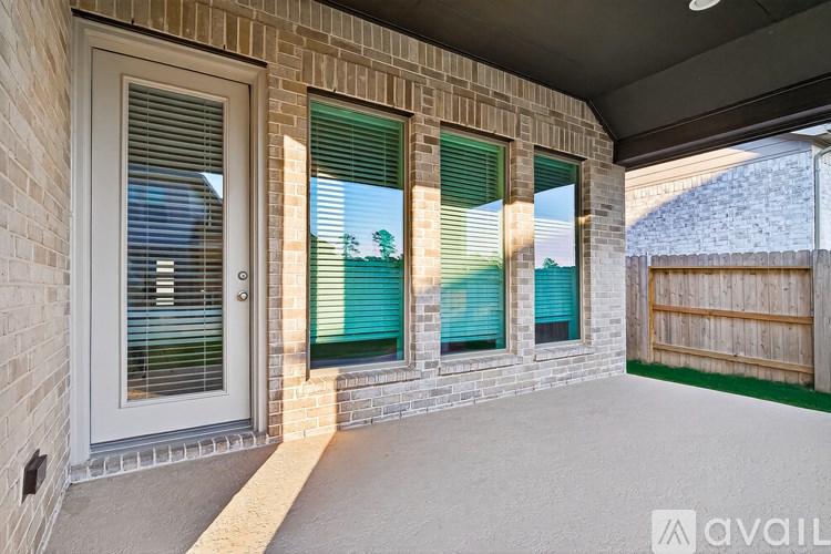 A patio area with a brick wall and a sliding glass door.