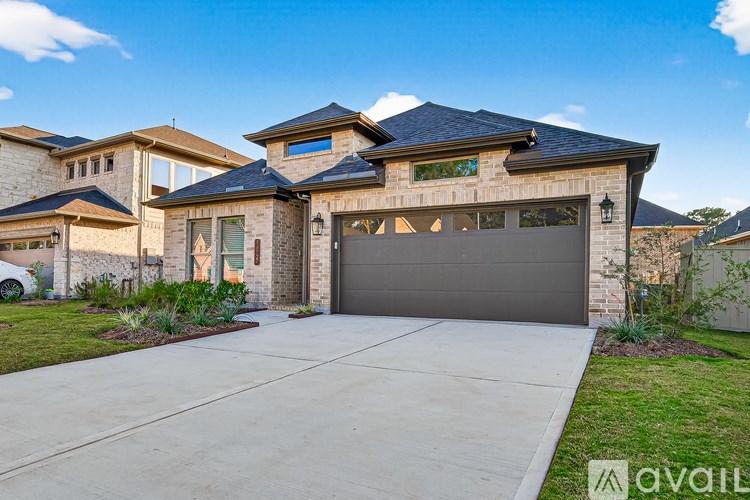 A house with a garage and a driveway in front of it.