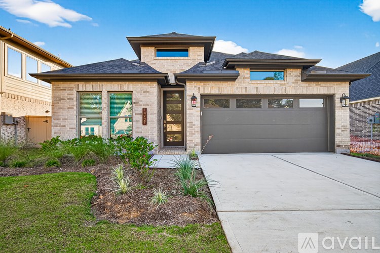 A modern house with a large front yard and a garage.