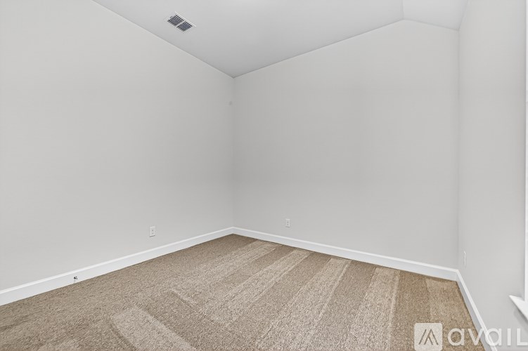 A room with a carpeted floor and a white wall.