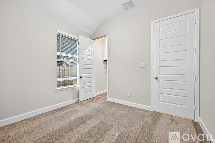 A room with a carpeted floor and a white door.