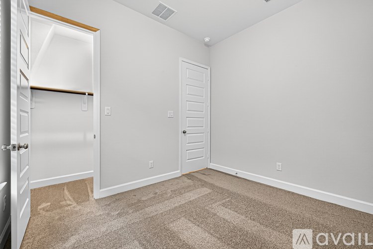 A room with a carpeted floor and two doors.